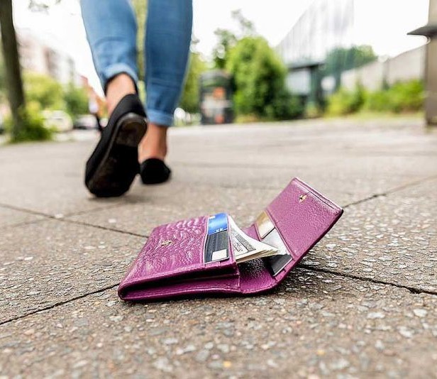 imagen de una billetera tirada en el piso, y su dueña yéndose del lugar sin darse cuenta.