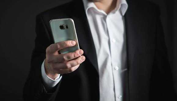 imagen de un hombre sosteniendo un celular tras recibir una notificación.